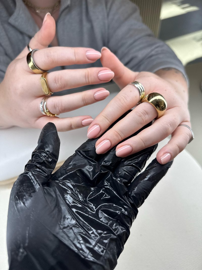 Nude nagels met gouden en zilveren ringen